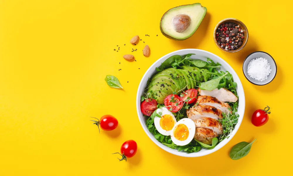 a bowl of salad with chicken and eggs